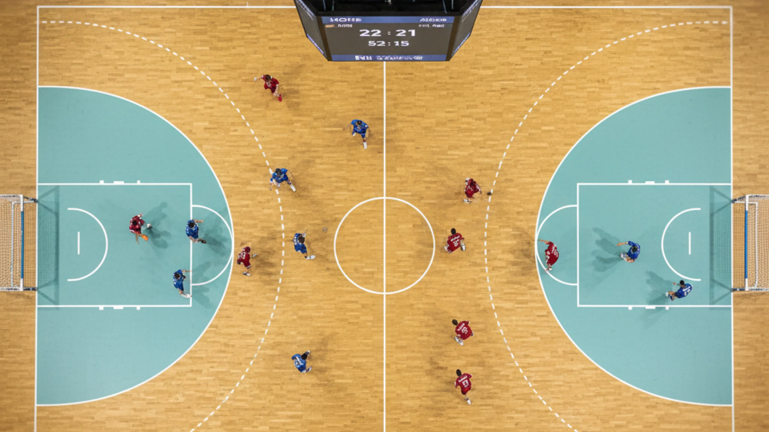 Professionelles Handballfeld während eines Bundesliga-Spiels mit sichtbarer Spielfeldstruktur und Mannschaften